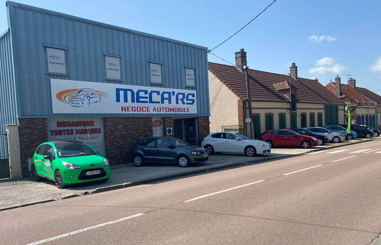 Devanture du garage Meca'rs avec des voitures à vendre garées devant.